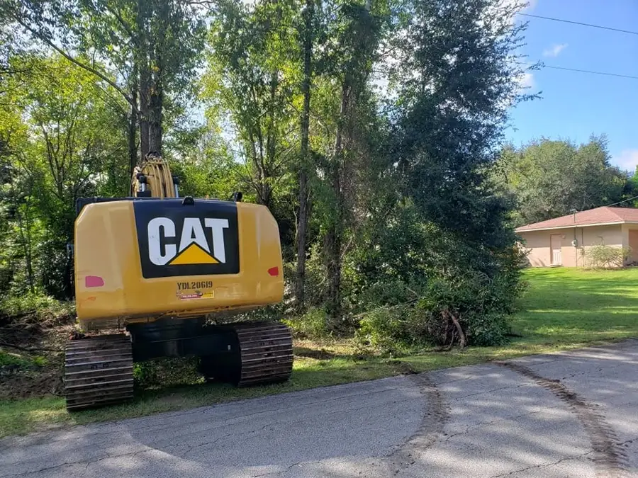 CAT excavator staged for stump removal work on a residential lot in Marion County