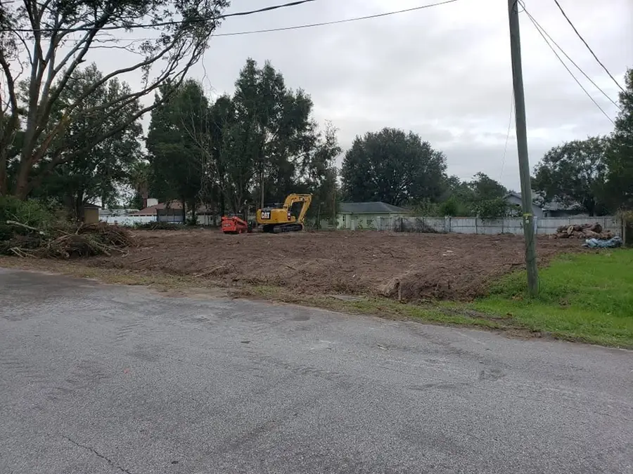 Excavator and skid steer working a residential demolition and lot clearing site in Ocala