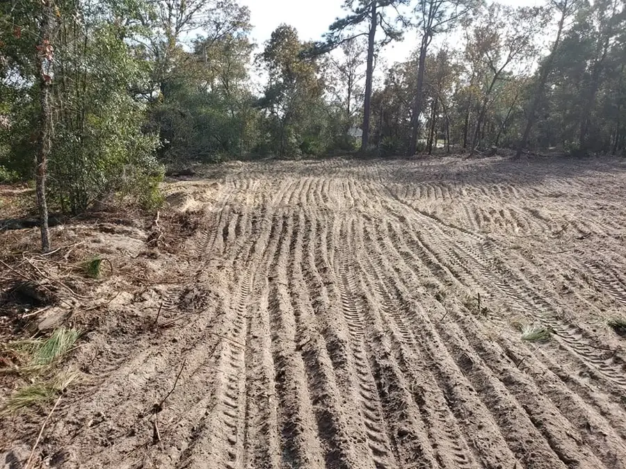 Freshly graded and leveled sand lot with heavy equipment track marks in Marion County, FL